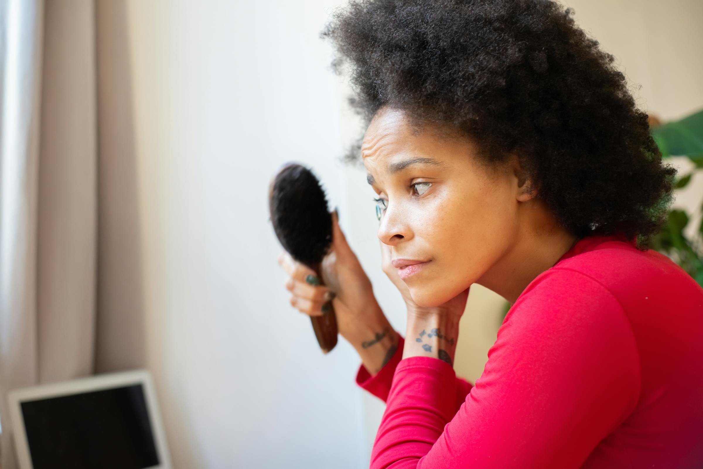 A woman gently brushing her natural afro